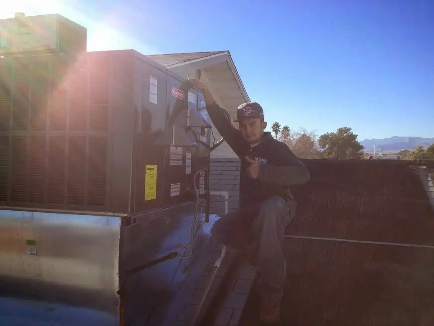 HVAC technician performing Air Duct Cleaning on a rooftop unit in Middleton